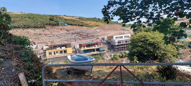 Quarry and home construction seemingly on the side of a hill. The next photo shows the same construction site from Seaton at sea level.