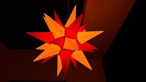 Die Herrnhuter Sterne, wie dieser, erhellen in den Fenstern und Gärten das dunkle Dorf. 🌟