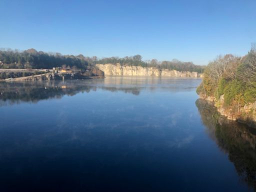 Quarry with tiny wisps of fog drifting across the water.