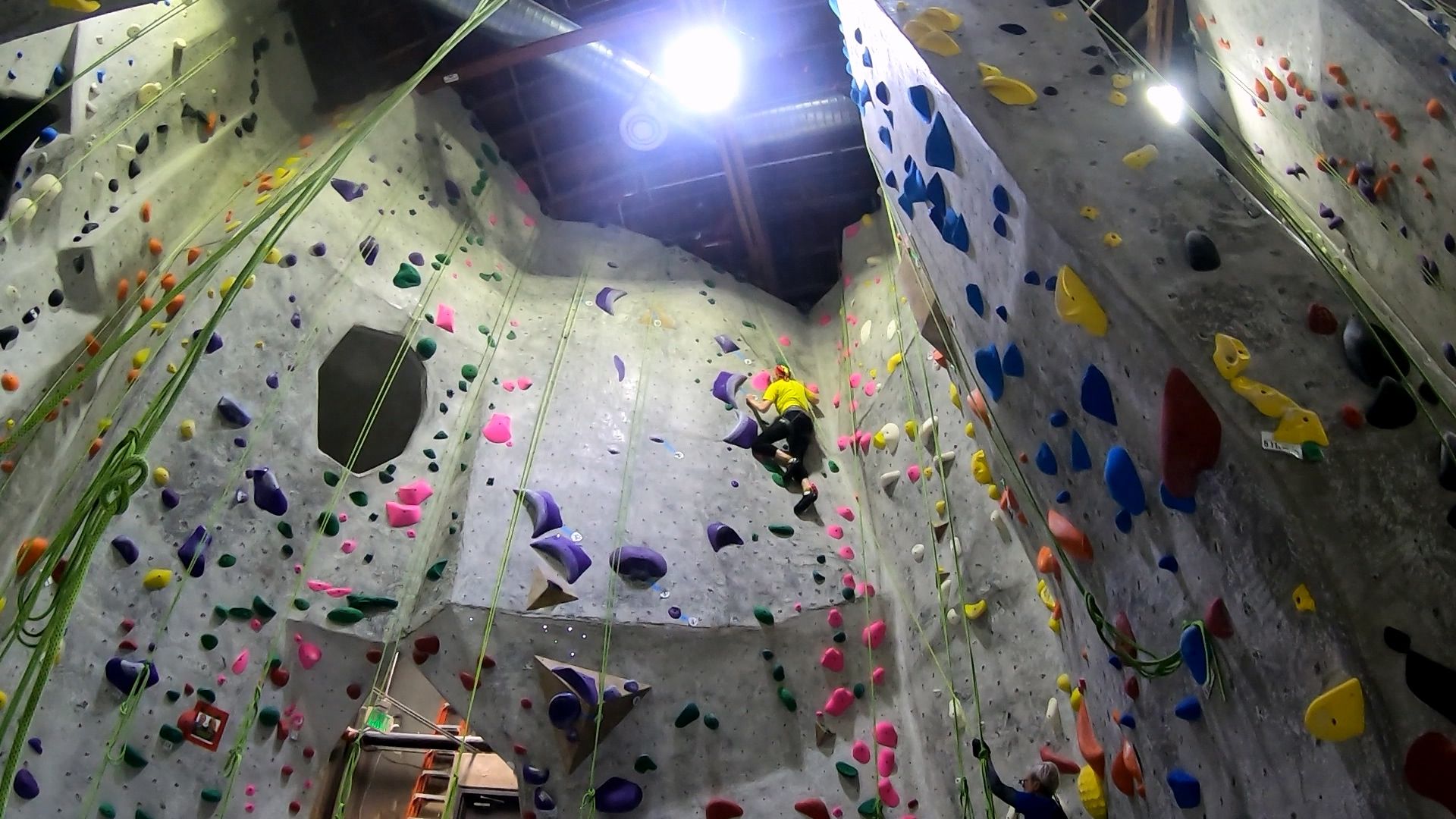 Climb 4 - Green 5.10c (T*): This new climb on the Back Corner slab next to the Pink 5.9 starts with an interesting traverse on decent jugs on the lower overhung wall.  I got through the traverse, and then got myself over the crease onto the lower end of the slab without trouble, but then the hand holds (and some foot holds) all went to crimps, some of them tiny.

In spite of this, I managed to keep myself close to the wall and to progress until I got about 2/3 of the way up when my fingers couldn't help me any longer, and I came off.

After hanging for about 40 seconds, I resumed and made progress toward the top without coming off again.  I see that after my break I reached for the tilted half-moon hold with my left hand, not my right.  Trying to grab it with my right hand might have been my undoing on my first attempt, in addition to fatigue.

Then near the top I found an awkward foot sequence on tiny jibs that involved crossing my legs before (*) back-stepping with my right foot onto a nice large pink blob instead of a tiny green jib.  It's as if my leg/foot had a mind of its own and went for the more secure hold.

I think if my fingers weren't as fatigued by this point I might be able to nail the jib instead of the pink blob.  But, a couple moves earlier if I can get my left foot out on the jib to the left of a large purple crescent, I wouldn't need to cross my legs and make any awkward steps.  Then I could probably get my right foot onto the green jib easily.

The other question, of course, is whether my fingers can maintain strength on the slab without the mid-climb hang-dogging.