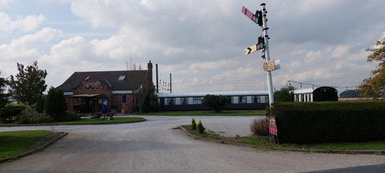 To the right on our route and for motorists, just off the A19: The Sidings hotel, Mediterranean restaurant and bar. Started in 1985 by a former railwayman. Built with 5 "Pullman style" carriages, next to the East Coast Main Line track, which diners can view.  https://thesidingshotel.co.uk