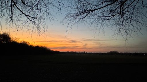 Das letzte Licht der Sonne, die bereits vor dreißig Minuten hinterm Horizont verschwandt, taucht den Himmel über der Kleingartenanlage Märchenland in ein warmes Orange. Die Uhr zeigte inzwischen 18.26 Uhr an.