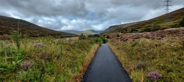 At 22.7 miles, 3.2 from Drumochter Summit, this is best viewed on a large screen: apart from the beauty, River Garry on the left, then rail track, this track, the separated north and south roads of the A9, electricity pylons, low cloud in the distance.