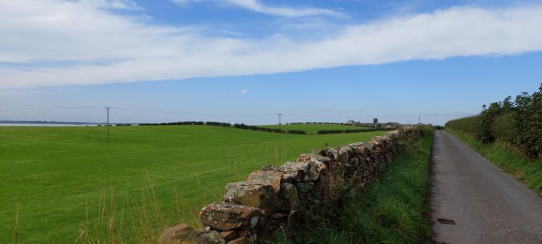 Change of landscape, again. Un-named road reached by turning right off Church Road, Dornock.  River Eden (after the Rivers Eden and Esk have merged and before they become the Solway Firth) is seen on the left.