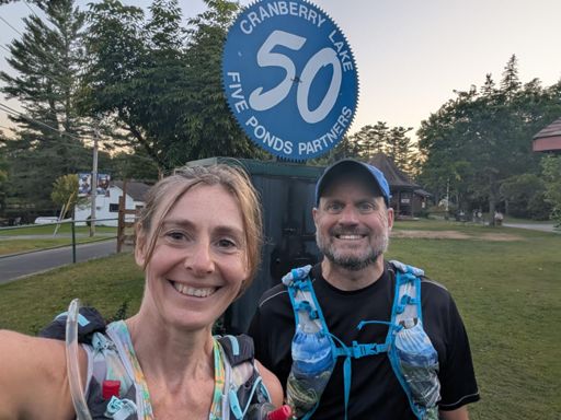 Forced smiles at the sign in Wanakena... Only .5 miles to go! 