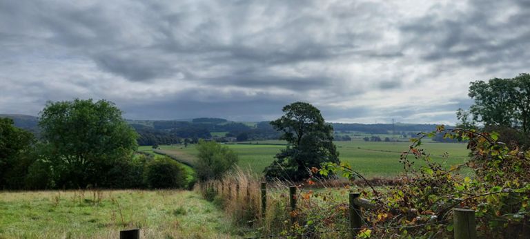 About 3 miles from Garstang. The horizon has a clump of trees, and a grey mass either side which at first looks like heavy cloud, rather than the distant hills they are!