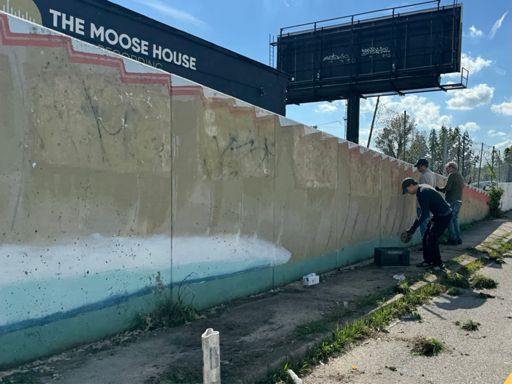 Artists cleaning and restoring the famous crocodile mural in Remington
