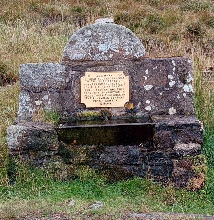 Erected by the Duke of Sutherland's road surveyor, Peter Lawson, acknowledging the locals' hospitality. This fascinating article narrates historical and geographic gems about our road from Durness to Rhiconich in reverse, including about the well, and has English translations for the Gaelic landscape features: http://helpful-mammal.co.uk/2019/10/13/ccxvii-rhiconich-to-durness/