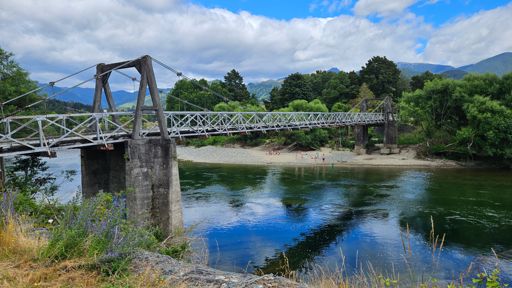 The Peninsular Bridge over the Motueka River. I'm always a little nervous riding over it - the gaps between some of the planks are about the width of my 23mm road tires. On the far bank kids playing in the river. Notice  the ropes hanging from the bridge - what fun.