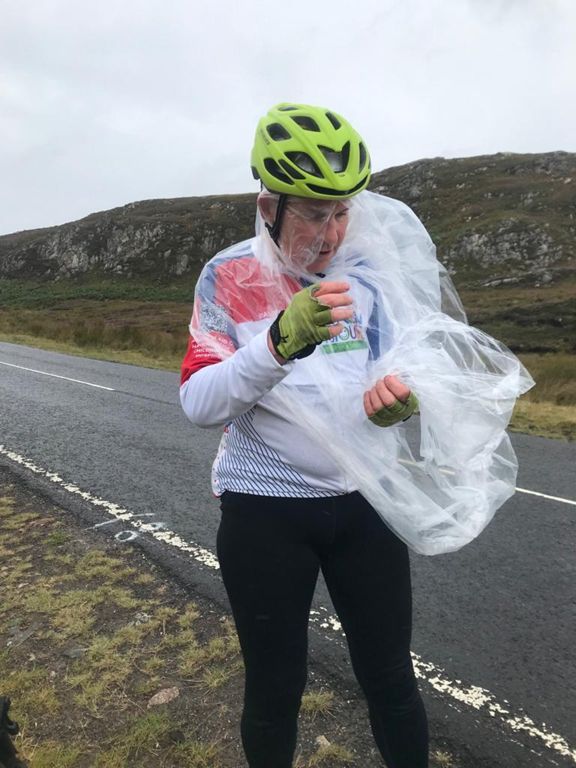 Putting a £1 transparent poncho on in a gale