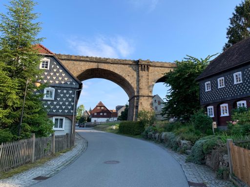 Typisch für die Oberlausitz sind Umgebindehäuser wie diese in Obercunnersdorf. Auf dem Eisenbahnviadukt, das ebenfalls das Dorfbild prägt, fuhr 1998 zum letzten Mal ein Zug von Löbau via Herrnhut nach Zittau.