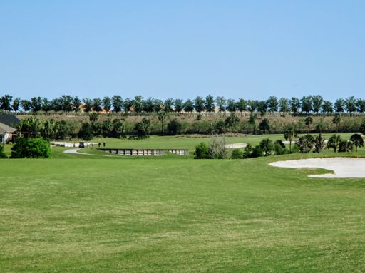 In the middle of The Villages behind this golf course beyond the line of trees lies . . . . . .