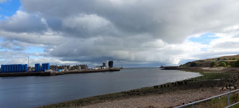 L>R: Seemingly (from Google Maps' Streetview) unused blue silos - there's a waste treatment plant on Pocra Quay, 1809 Footdee planned housing, (white) Silver Darling global fish restaurant, 1798 Roundhouse and its 2006 Marine Operations Centre replacement, 1781 North Pier designed by John Smeaton whose work we saw on Days 29 and 41, the  North Sea with dramatic cloud above - I took the photo for this, thinking of rain which never came and the river mouth, lighthouse at the end of the south breakwater, part of Balnagask Golf Course on the headland. https://en.wikipedia.org/wiki/Footdee &  https://canmore.org.uk/site/282569/aberdeen-harbour-north-pier-marine-operations-centre