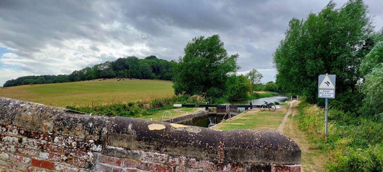 View west from Dreweatt's Lock and Bridge (Lock 79, Bridge 71) with Irish Hill Copse to the left. Constructed between 1794 and 1810.  https://historicengland.org.uk/listing/the-list/list-entry/1117230