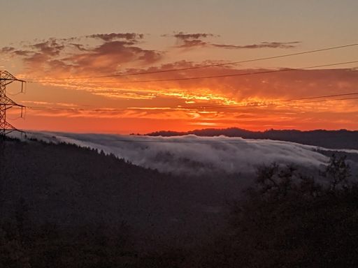 Cloudy sunset as the fog rolls over the ridge.