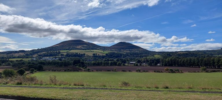 We saw a painting of The Three Sisters in the bistro restaurant at the hotel last evening. Here are two of them, viewed to our right/south from the :B6360 on the north side of the River Tweed (l>r): 1325ft/404m Eildon Hill North and further south: 1385ft/422m Eildon Mid Hill. Out of sight behind that is 1217ft/371m Eildon Wester Hill. https://www.walkhighlands.co.uk/borders/eildon-hills.shtml