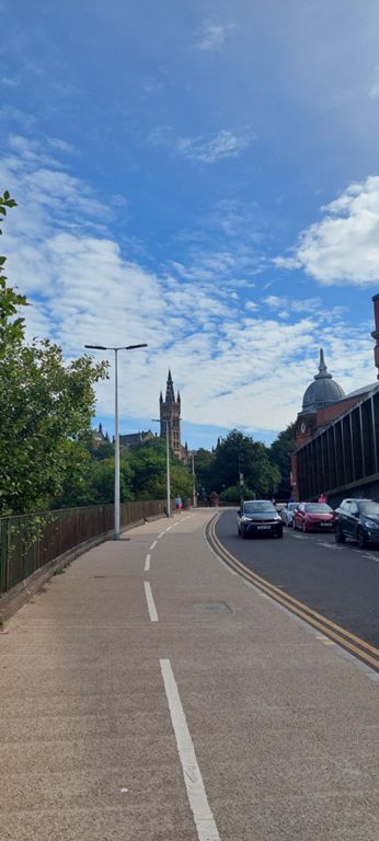 Shared path beside the one way Bunhouse Road on route towards University of Glasgow campus. The spire is for the tower of the university's main Gilbert Scott Building completed in 1891; the dome is that of 1927 Kelvin Hall on the corner of this road and Argyle Street.  About the Gilbert Scott Building: https://www.gla.ac.uk/explore/visit/attractions/tour/gilbertscottbuilding/   About Kelvin Hall: https://en.wikipedia.org/wiki/Kelvin_Hall