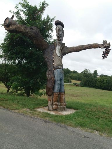 Statue en bois à la gloire du vignoble local, au pied de la petite côte du village de Fabas.