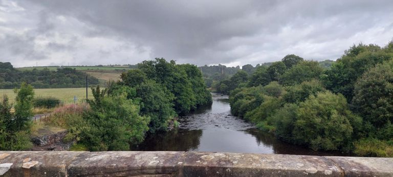 View to the right, north, of Avon Water, north of Stonehouse, with Stonehouse Viaduct bridge pillars in the background
