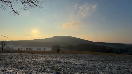 Dünne Wolken spielen noch mit der langsam untergehenden Sonne überm Königsholz. 🌞☁️