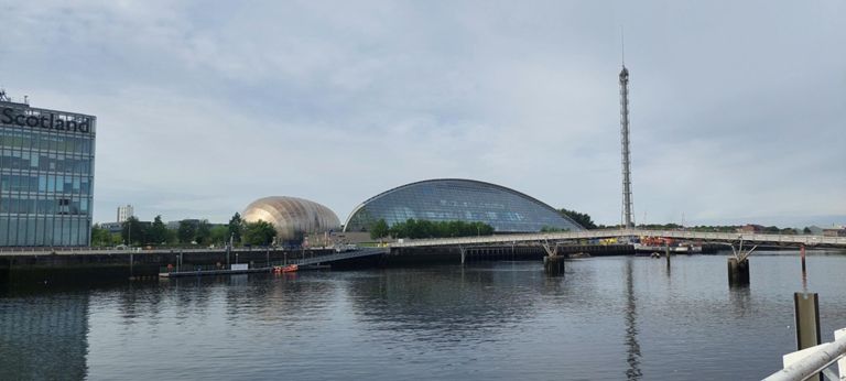 Left to right: right side of BBC Scotland, 3 sections of the Glasgow Science Centre: golden IMAX Theatre, Edam cheese slice-like Science Mall, then the Glasgow Tower. In front of all is the Millennium Bridge, opened in 2002.  The GSC was designed by the Building Design Partnership. The theatre opened in 2000, the mall in 2001 and the tower was completed in 2001.   https://en.m.wikipedia.org/wiki/Glasgow_Science_Centre  https://en.wikipedia.org/wiki/Glasgow_Tower  https://en.wikipedia.org/wiki/Millennium_Bridge,_Glasgow