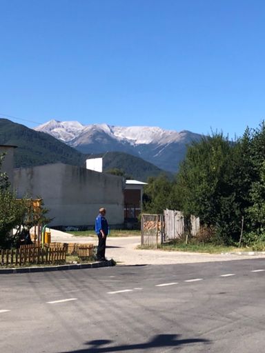 Vihren, slightly to right of the green tree covered mountain in foreground.